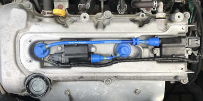 closeup of engine cover which show blue suzuki sport plug leads