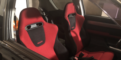 two red and black Recaro seats in a swift